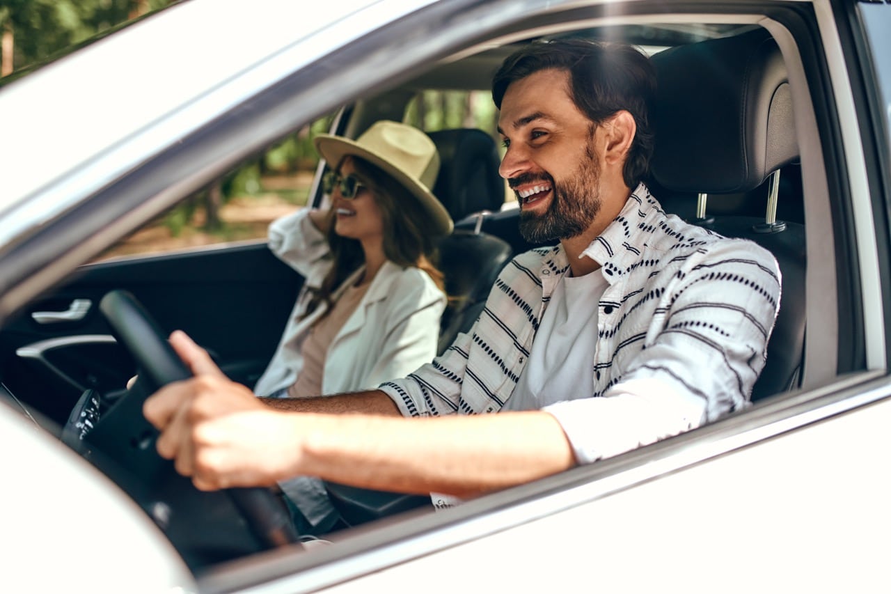 Un couple souriant et satisfait dans leur voiture neuve obtenue grâce à un contrat de leasing adapté à leurs besoins.