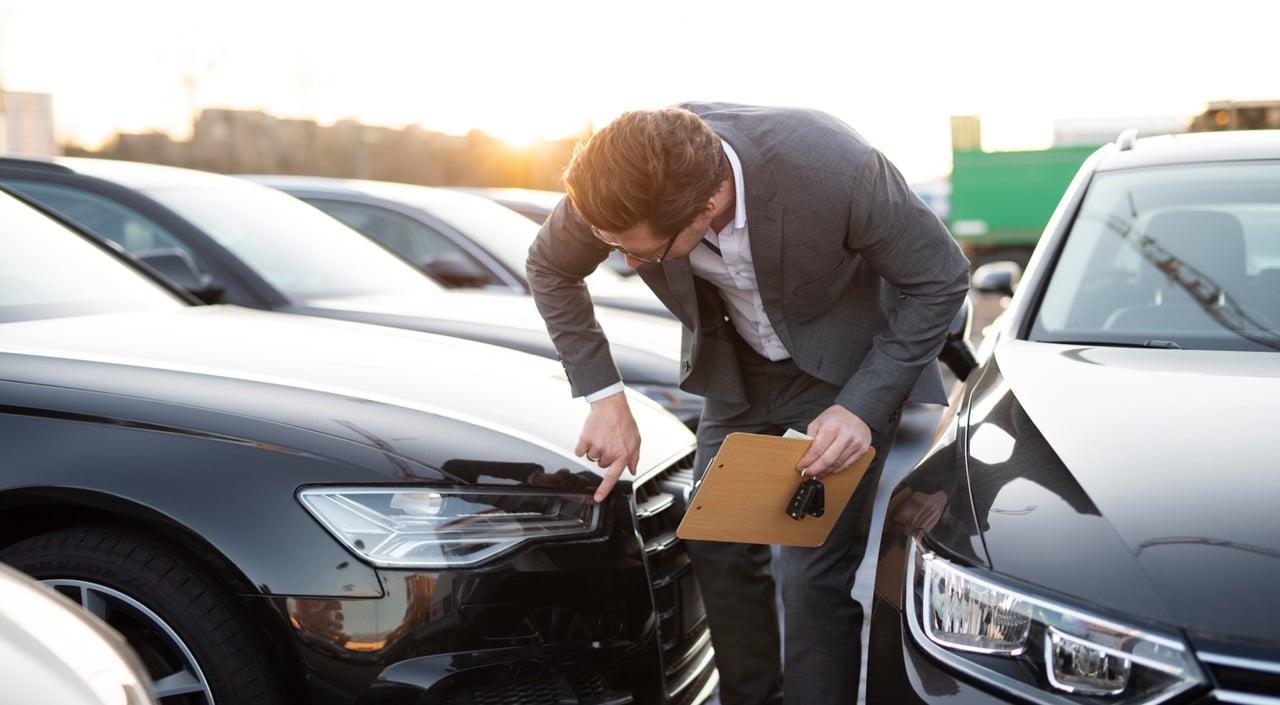 Un leaseur qui inspecte une voiture qu'il va remettre à un client qui a choisi le leasing